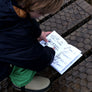 Kid checking off the illustrated Nature Quest Scavenger Hunt Book