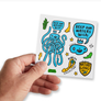 Male hand holding up sticker sheet with thirteen Keep Tassie Wild ocean stickers