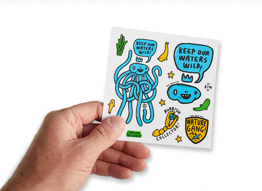 Male hand holding up sticker sheet with thirteen Keep Tassie Wild ocean stickers