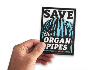 Male hand holding up save the organ pipes bumper sticker to preserve Mt Wellington