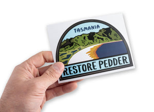 Male hand holding bumper sticker supporting the restoration of Tasmania's Lake Pedder 