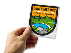 Male hand holding Wineglass Bay Freycinet National park bumper sticker made in Tasmania (Lutruwita)